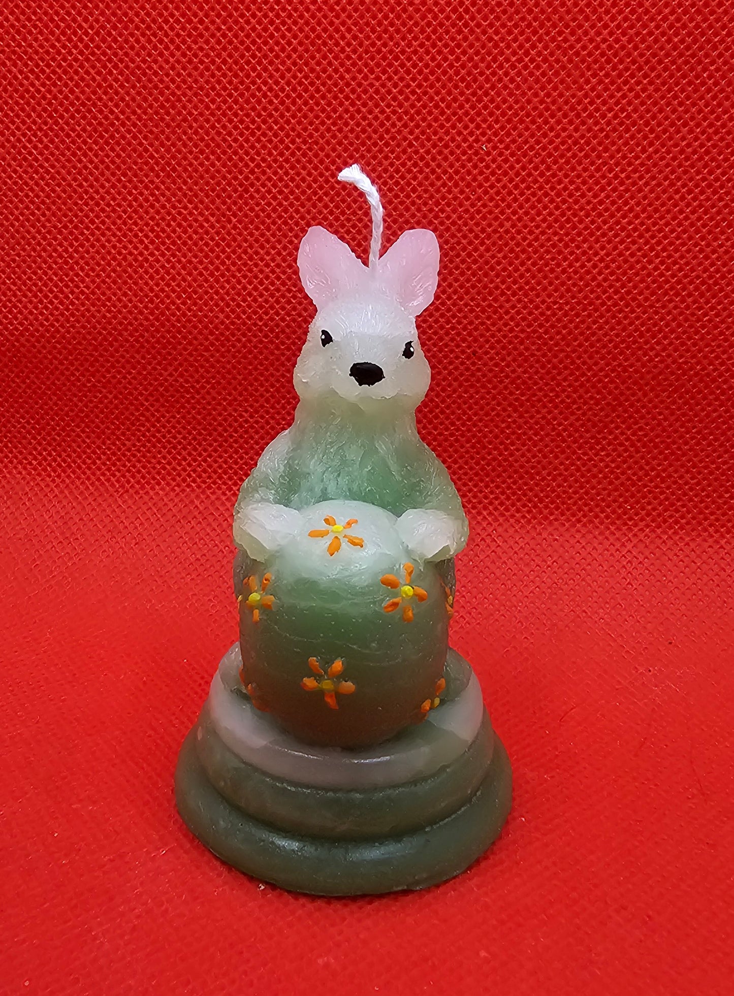 Hase grün mit Ei auf Podest